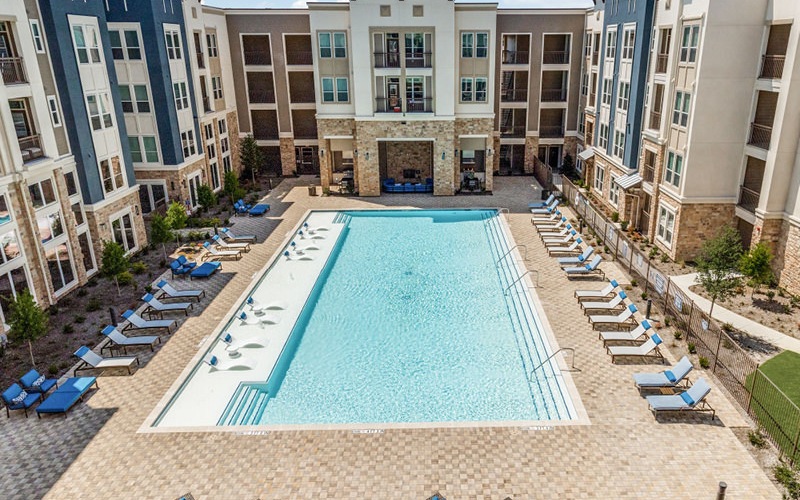Large pool with shaded seating and clubhouse access.