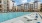 Pool side area at our apartments in Allen, TX, featuring cushioned outdoor seating and a view of The Sovereign at Twin Creeks. 